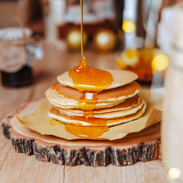 festive dessert table homemade cakes, pancakes with honey, pour honey on pancakes