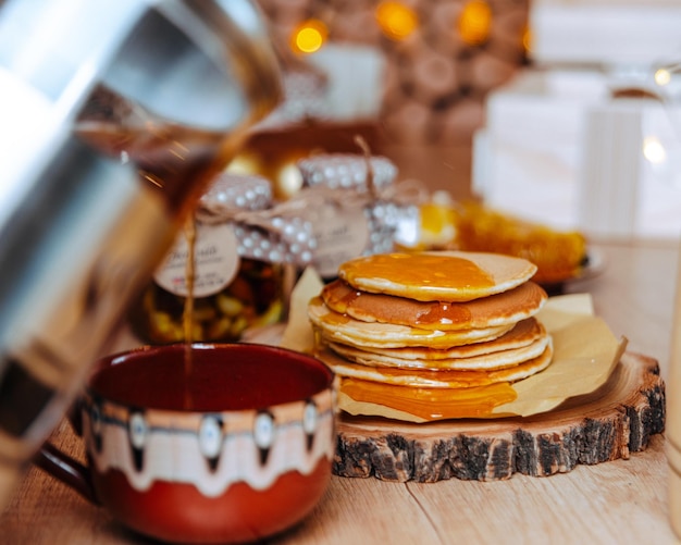 festive dessert table homemade cakes, pancakes with honey, pour honey on pancakes