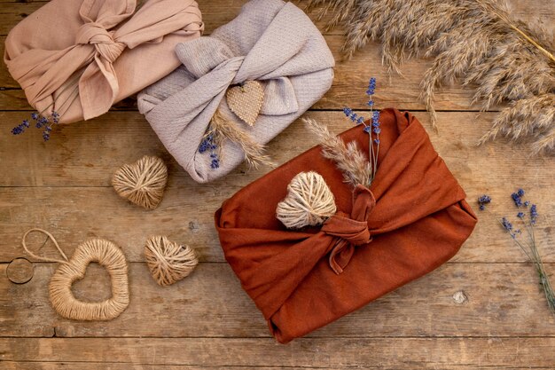 Festive flatly of gifts packed in furoshiki style on wooden table. Zero waste Valentine's Day concept