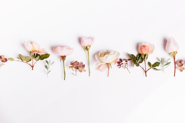 Festive flower composition on the white wooden background Overhead view