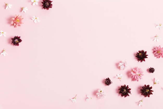 Festive flowers composition Frame made of pink and purple small flowers on pink background