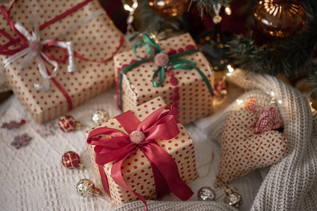 Festive gift boxes under the Christmas tree closeup