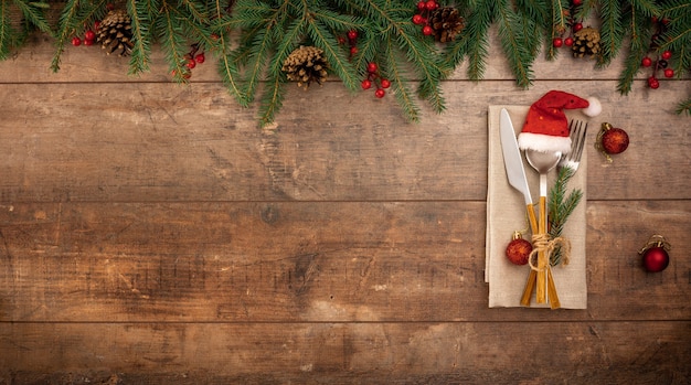 Festive New Year Christmas dinner concept Christmas decorations and Cutlery on dark rustic table