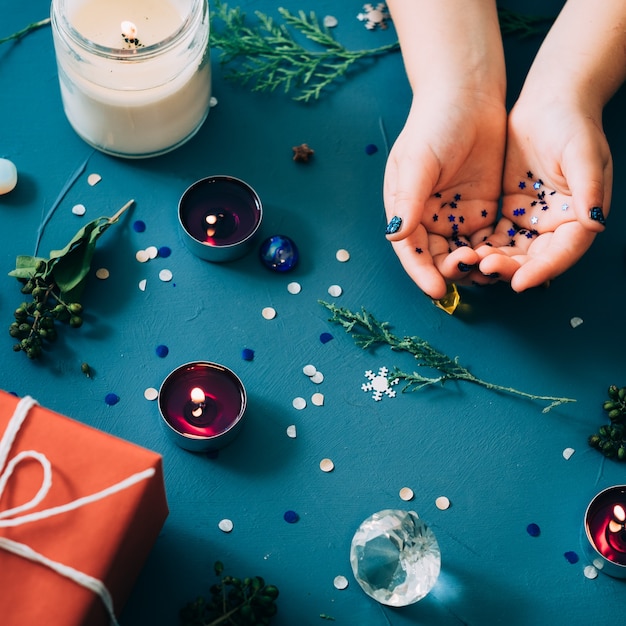 Festive new year decoration on blue wall. seasonal design of candles gift box and natural twigs. creative adornments.