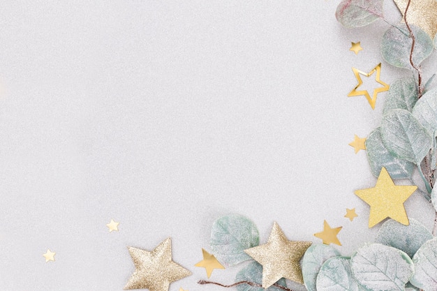 Festive pastel background. Christmas stars and shining glitter, confetti on pastel background. Christmas background, Flat lay.