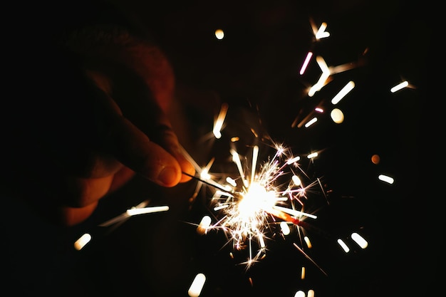 Festive sparkler with sparks in hands