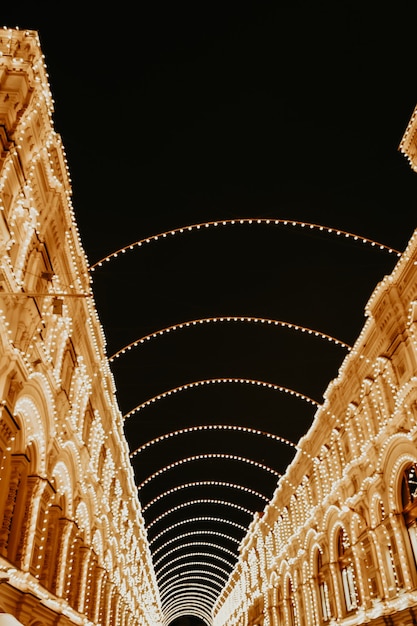 Festive sparkling garlands and gold decorations on the street. Happy New Year and Merry Christmas winter holiday celebration.