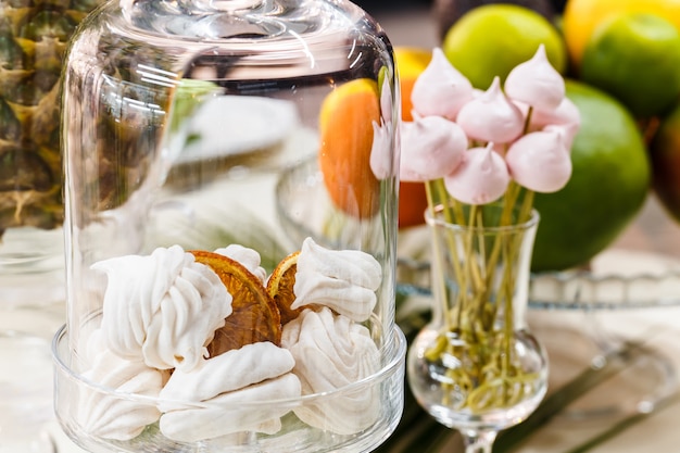 Festive table, decorated with vases, fruits and pastries.