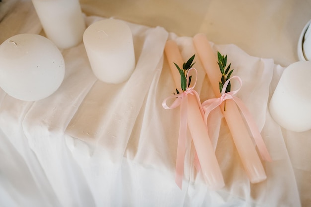 Festive table newlyweds covered with a tablecloth decorated composition of greenery candles in wedding banquet hall Close up Artwork Decor in style vintage Details Wedding inspiration