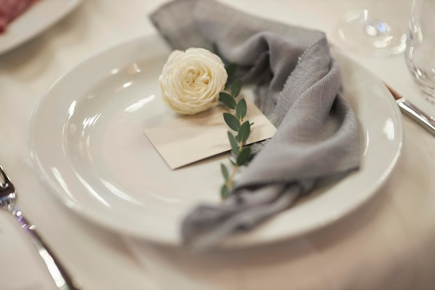 festive table setting gray towel and flower on a white plate