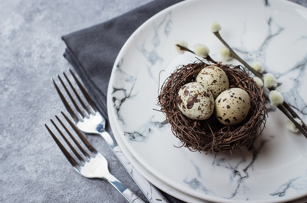 Festive table setting for holiday Easter dinner on gray stone concrete table 