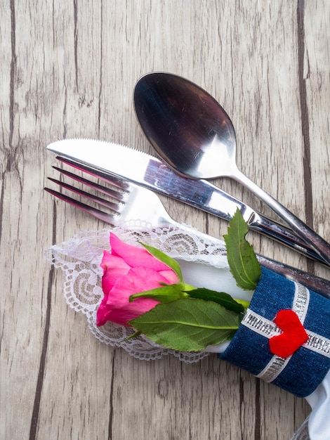 Festive table setting for Valentine's Day with cutlery roses and hearts on white wooden table Space for text