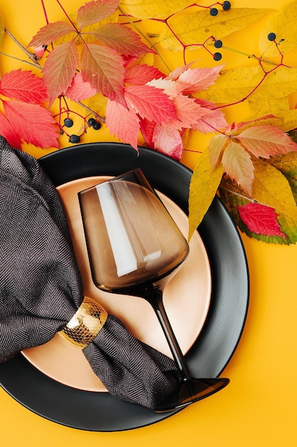 Festive table setting with Bright Autumn leaves on pastel background.