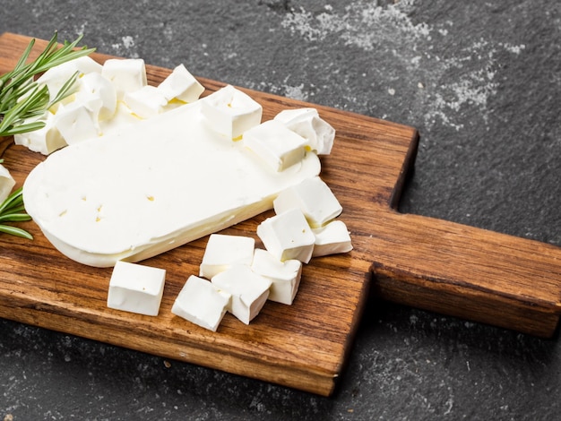 feta cheese on a cutting board on a stone background