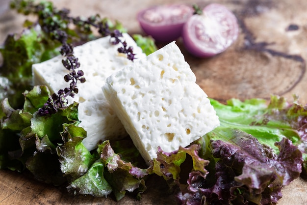 Feta goat cheese with green salad on rustic wooden