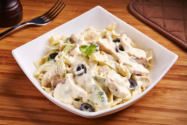 Fettuccine Chicken Mushroom with cream sauce and olive served in dish isolated on table side view of middle east food