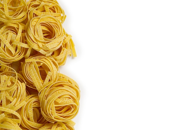 Fettuccine italian pasta isolated on white background raw tagliatelle nests isolated on white backgr...