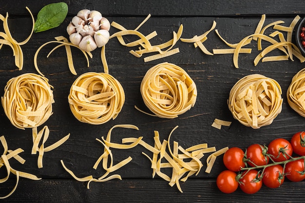 Fettuccine Tagliatelle pasta Italian food ingredients set on black wooden table background top view flat lay