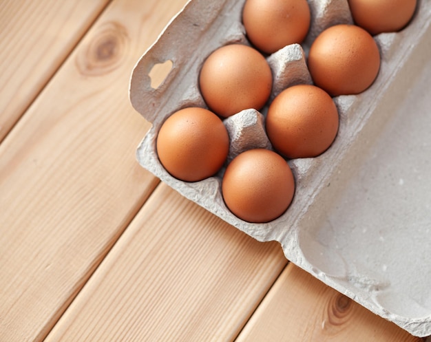 A few brown eggs among the cells of a large cardboard bag, a chicken egg as a valuable nutritious product, a tray for carrying and storing fragile eggs. A full package of eggs, an important food item