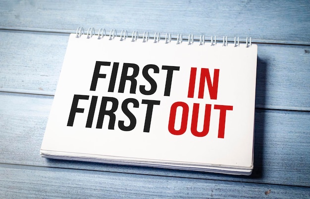 FIFO First in first out word notebook on wooden background