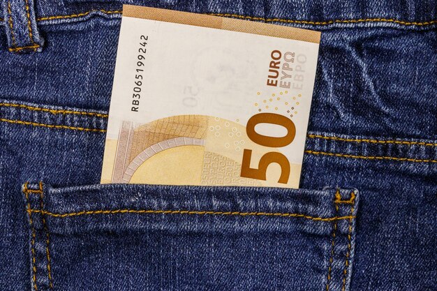 Fifty euro banknote in the pocket of blue jeans