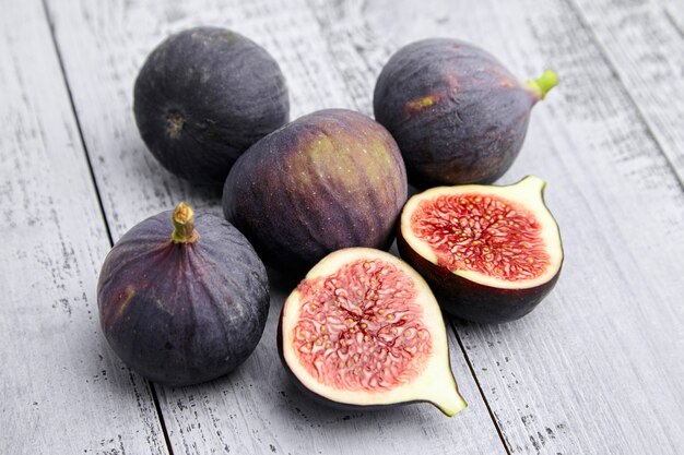 Fig fruit with red ripe halves on wooden table