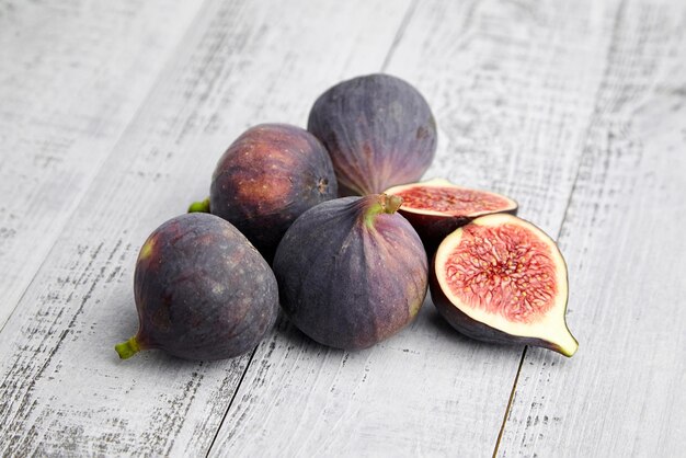 Fig fruit with red ripe halves on wooden table