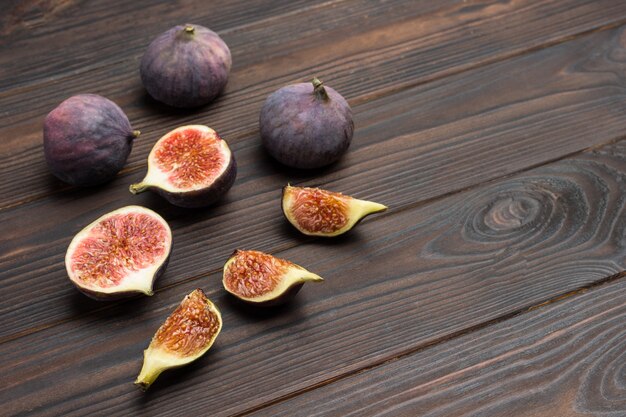 Fig fruits on wooden table. Fig halves, quarters and whole fruits.