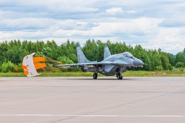 Fighter combat aircraft landed with a parachute released at a military base