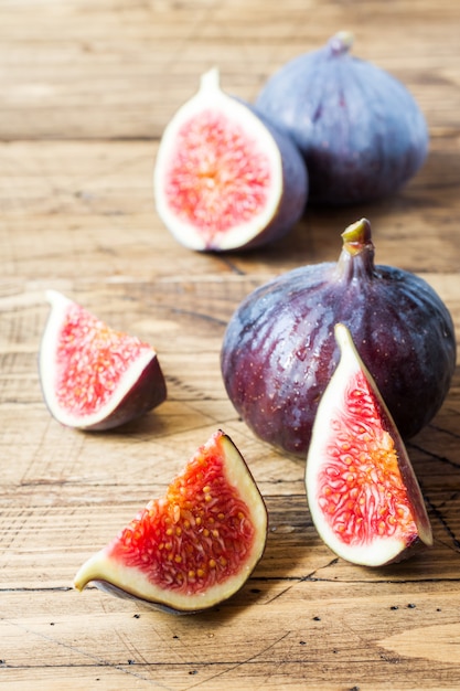 Figs are Fresh ripe whole and cut into a wooden old surface.