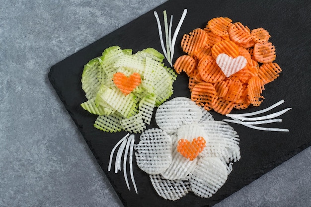 Figured slicing vegetables for vitamin salad to Valentine's Day