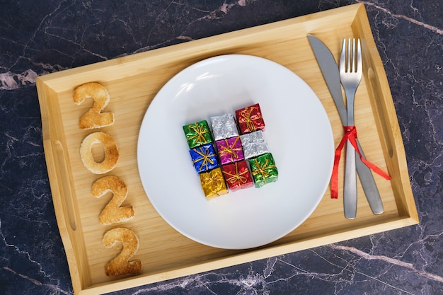 Figures 2022 and 2023, their breads cooked, lie on a wooden bamboo tray with a white plate in the background.