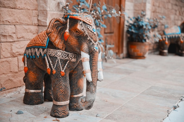 a figurine of a garden elephant stands at the entrance at the gate