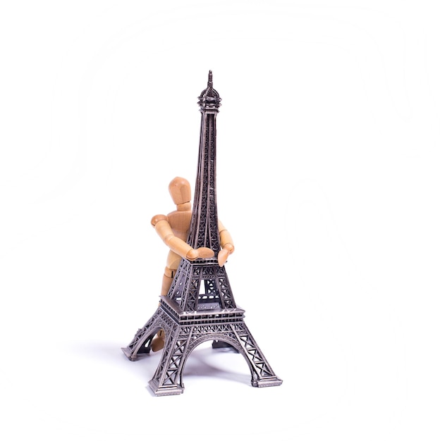 Photo a figurine of a man is hugging the eiffel tower.