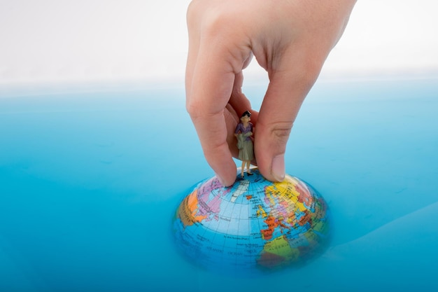 Figurine on the top of the globe in water