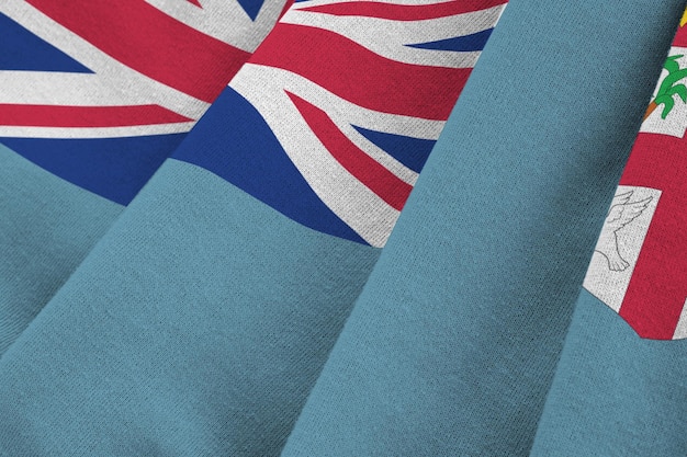 Fiji flag with big folds waving close up under the studio light indoors The official symbols and colors in banner