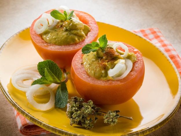 Filled tomatoes with avocado cream onion and paprika