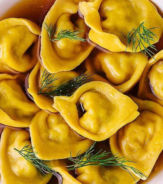 Filled tortellini with herbs close up