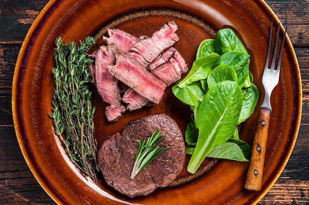 Fillet Mignon tenderloin roast and cut meat beef steaks in a plate with salad