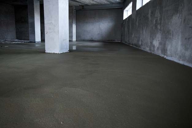 Filling the floor with concrete, screed and leveling the floor. Smooth floors made of a mixture of cement, industrial concreting