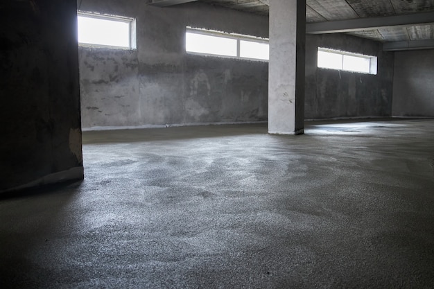 Filling the floor with concrete, screed and leveling the floor. Smooth floors made of a mixture of cement, industrial concreting