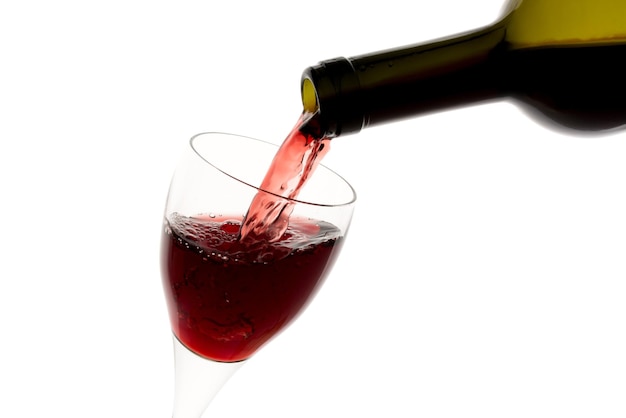 Filling glass with red wine from green bottle