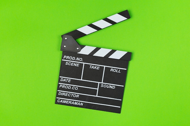 Film clapper board on green  top view