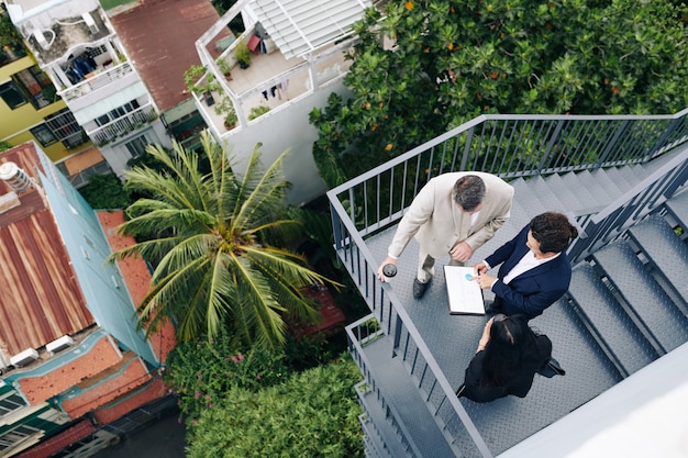 Finance department manager showing annual report to his colleagues, view from the top