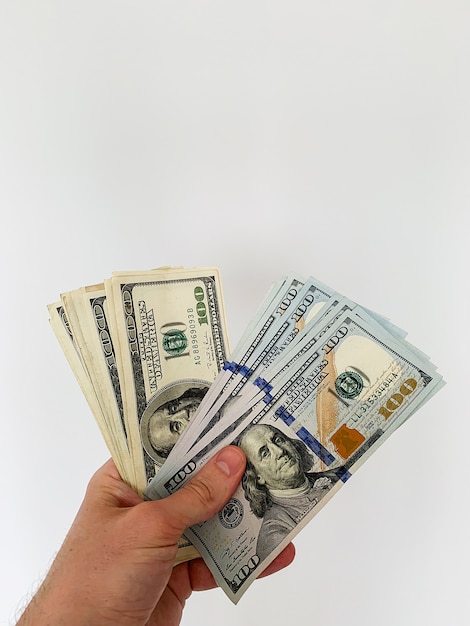 Finance money. Man holding a hundred dollars banknotes for rental or purchase flat