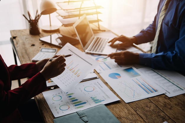 Financial analysts analyze business financial reports on a digital tablet planning investment project during a discussion at a meeting of corporate showing the results of their successful teamwork