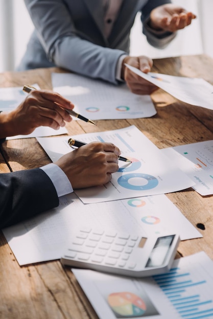 Financial analysts analyze business financial reports on a digital tablet planning investment project during a discussion at a meeting of corporate showing the results of their successful teamwork