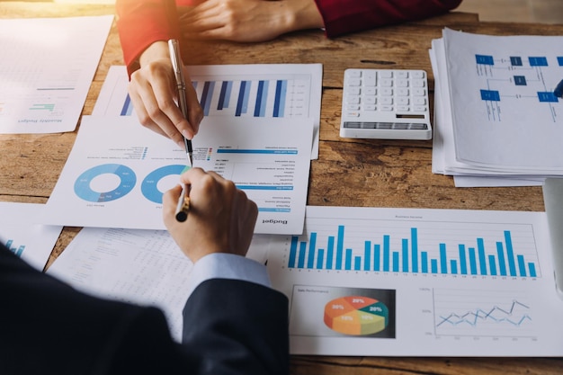 Financial analysts analyze business financial reports on a digital tablet planning investment project during a discussion at a meeting of corporate showing the results of their successful teamwork