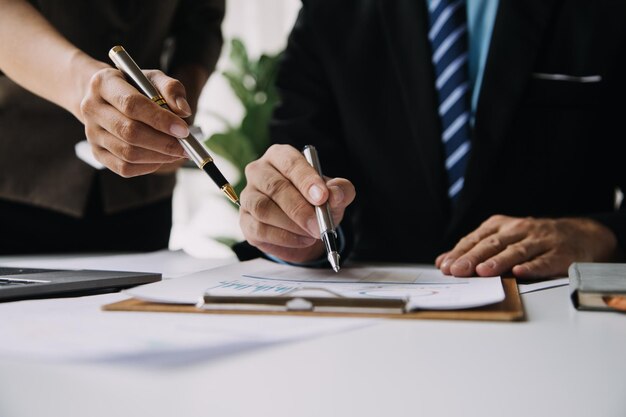 Financial analysts analyze business financial reports on a digital tablet planning investment project during a discussion at a meeting of corporate showing the results of their successful teamwork