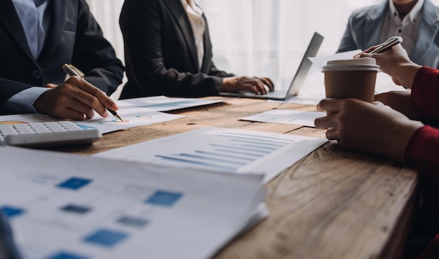 Financial analysts analyze business financial reports on a digital tablet planning investment project during a discussion at a meeting of corporate showing the results of their successful teamwork